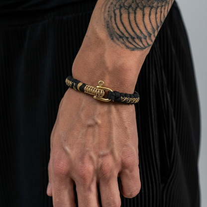 men's woven paracord survival bracelet with metal shackle on wrist