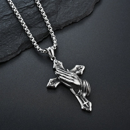 Close up of praying hands cross pendant on stainless steel chain
