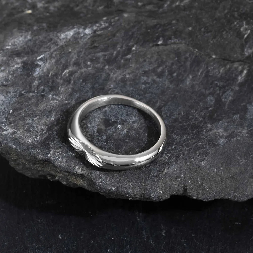 Close up of engraved sunburst pattern stainless steel ring