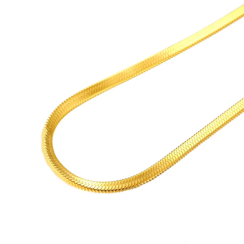 Close up of gold flat snake chain necklace worn by male model