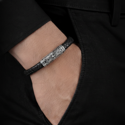 men's leather bracelet with engraved cross centerpiece on wrist