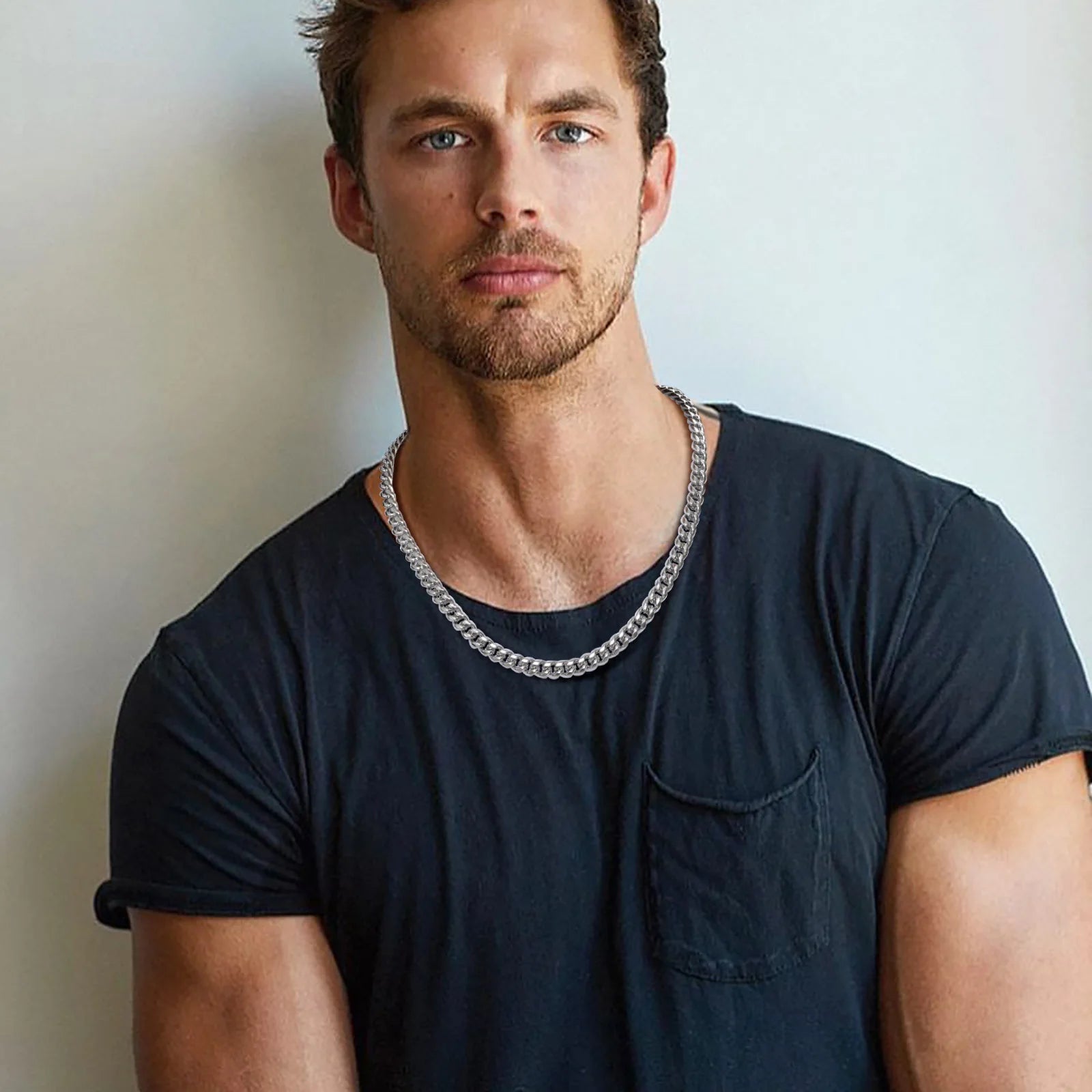 Man wearing a polished stainless steel Cuban link chain necklace with thick interlocking curb links