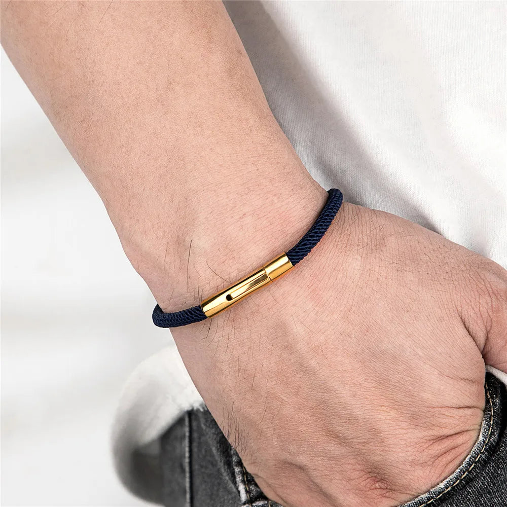 hand wearing a modern men's cord bracelet with sleek gold clasp