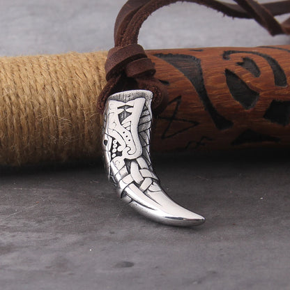 Close up of wolf fang pendant on leather cord necklace