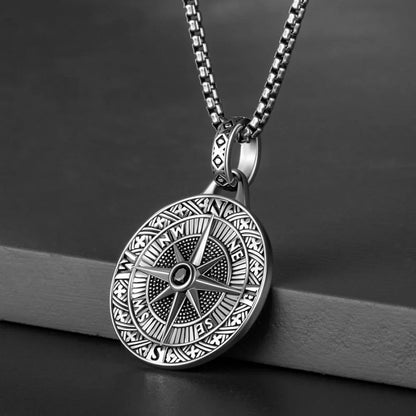 Close up of compass rose pendant necklace on stainless steel chain